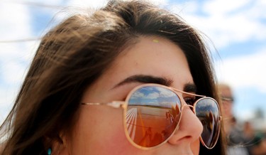 The runway is reflected in Nefeli Kotopoulos' sunglasses during the Wings Over Springbank air show at Springbank Airport west of Calgary on July 19, 2015.