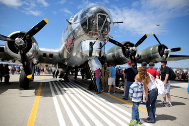 Crowds gather to look tat the WW II b-17 bomber Sentimental Journey in the background during the Wings Over Springbank air show at Springbank Airport west of Calgary on July 19, 2015.