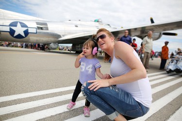 Chelsea Fornataro and her daughter Hayley, 20 months, look to the skies during the Wings Over Springbank air show at Springbank Airport west of Calgary on July 19, 2015.