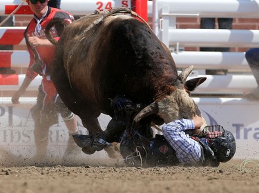Bull rider Trey Benton III  of Texas, has a close call with Wrangler Extreme during the Calgary Stampede Bull Riding Championship.