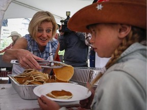 Alberta Premier Rachel Notley serves up pancakes at the annual Premier's Stampede breakfast in Calgary, Alta., on Monday, July 6, 2015.