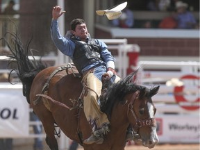 Tanner Aus loses his hat during the bareback event at the Calgary Stampede Rodeo at the Stampede Grandstand in Calgary on Saturday, July 4, 2015.