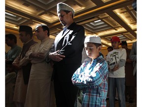 Muzaffar Sultan and his son Sherg, age 13, pray during the Eid ceremony, marking the end of the holy month of Ramadan, at Baitun Nur Mosque mosque. Muslims attend the congregational Eid prayer service the morning after the end of Ramadan.