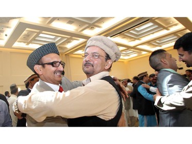 Mahmood Ahmed, left, and Nasrulah Bhatti embrace following the Eid ceremony, marking the end of the holy month of Ramadan, Saturday July 17, 2015 at Baitun Nur Mosque mosque. Muslims attend the congregational Eid prayer service the morning after the end of Ramadan.