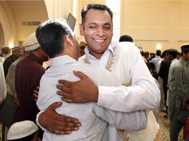 Mansoor Mansoor embraces a fellow worshipper following  the Eid ceremony, marking the end of the holy month of Ramadan, Saturday July 18, 2015 at Baitun Nur Mosque mosque. Muslims attend the congregational Eid prayer service the morning after the end of Ramadan.