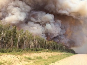 Smoke billows from a forest fire along highway 969 in southern Saskatchewan on June 29, 2015. Saskatchewan Premier Brad Wall says the province has spent its firefighting budget for the year. But Wall says he's not worried about money right now and the government's priority is to keep fighting wildfires in the north.