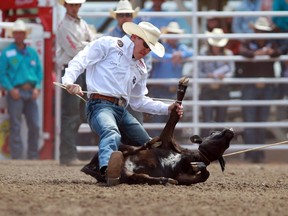 Marty Yates of Stephenville, Texasties up his calf  in 7.5 seconds to win day money on Monday at the Calgary Stampede