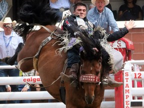 Caleb Bennett rides Knight Rocket during the bareback championship at the Calgary Stampede on Tuesday. The 2013 champion is known for spending his money wisely, investing in a house instead of toys.