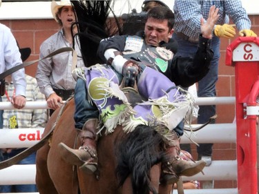 Caleb Bennett rides Knight Rocket during the bareback championship at the Calgary Stampede in Calgary, on July 7, 2015.