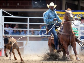Fred Whitfield from Hockley, Texas, ropes his calf during the Calgary Stampede tiedown roping championship.