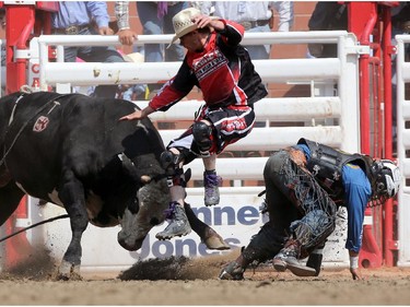 CALGARY.;  July 10, 2015, 2015  -- A bullfighter gets between the bull and Stetson Lawrence during the Calgary Stampede Bull Riding Championship. Photo Leah Hennel/Calgary Herald