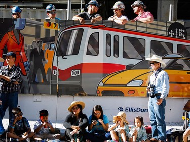 Construction workers and spectators watch during the Calgary Stampede parade in Calgary, Friday, July 3.