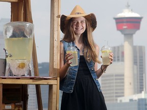 Thirteen-year-old entrepreneur Alina Moore holds up the lemonade she is selling from her stand overlooking the Stampede grounds from the front lawn of her family's Ramsay home Tuesday, July 8.