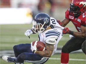 Calgary Stampeders defender Keon Raymond yanks Toronto Argonauts slotback Chad Owens to the ground in Monday's game. The Stamps leaned on their defence to get the job done after their offence stalled when injuries ravaged the offensive line.
