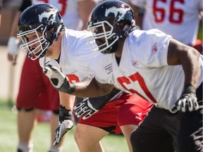 Stampeders offensive linemen Shane Bergman, left, and Garry Williams practise at McMahon Stadium on Thursday,