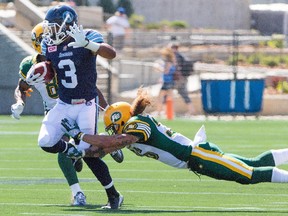 Toronto Argonauts running back Brandon Whitaker sidesteps a tackle from Edmonton Eskimos' Aaron Grymes under pressure from Cauchy Muamba during their meeting last month.