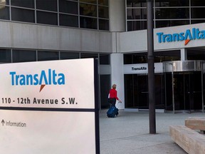 A woman walks towards the entrance of the TransAlta headquarters building in Calgary, on Tuesday, April 29, 2014.