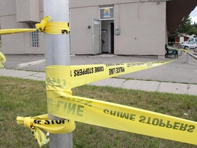 Crime scene tape surrounds the McMan Youth, Family and Community Services building on 19th Street at Northmount Drive NW, the scene of an overnight fatal stabbing Sunday, July 18, 2015.