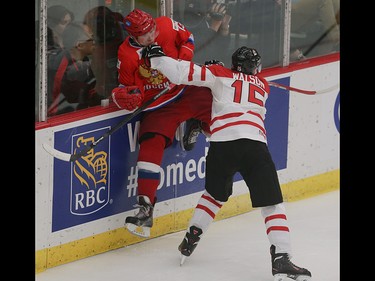 Team Russia player Andrey Kuzkemenko, left, is pushed up into the boards by Team Canada player Spencer Watson in the opening game of the World's Junior Showcase at the Markin MacPhail Centre in Calgary on Monday, Aug. 3, 2015. Team Canada led over Team Russia, 3-1, at the end of the second period.
