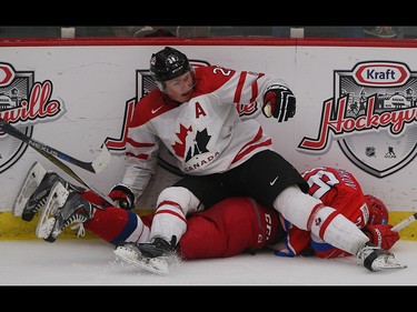 Team Canada player Lawson Crouse, centre, ends up on top of injured Team Russia player Egor Korshkov in the opening game of the World's Junior Showcase at the Markin MacPhail Centre in Calgary on Monday, Aug. 3, 2015. Team Canada won over Team Russia, 4-1.