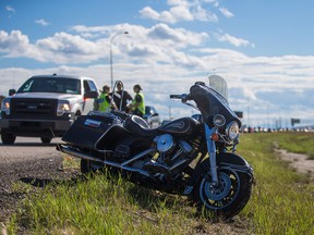 A motorcycle stands upright after being moved by police following a crash north of Country Hills Boulevard on Deerfoot Trail in Calgary on Friday, Aug. 7, 2015. The sole rider and person involved with the crash, a man in his 60s, was transported to hospital after losing control of the motorcycle. Police indicated that he was expected to recover.