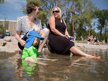 Aderyn Zajicova, left, and Sonya Bradley enjoy an afternoon in the Bow River wadding pool with their families  at St. Patrick's Island in Calgary on Monday, Aug. 10, 2015.