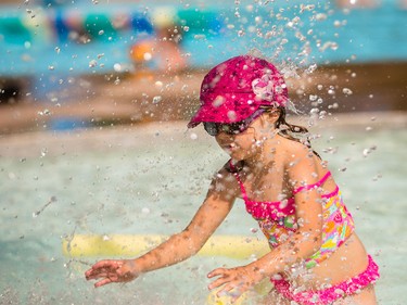Kirsi Doucher, 5, braves the mushroom sprinkler at Bowview Outdoor Pool in Calgary on Monday, Aug. 10, 2015. Dawn Doucher, Kirsi's mother, says Kirsi often avoids the sprinkler because she says it "feels like hail."