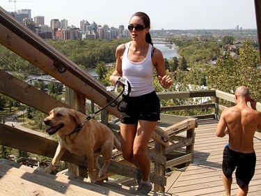 Courtney Lavalee and her golden lab Reese work up a sweat as they run up the McHugh Bluff steps above Memorial Drive Monday August 10, 2015. The weather is expected to stay hot all week.