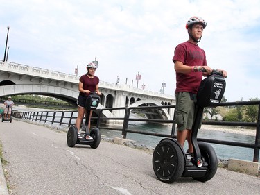 Nathan Lia and their dad William Chan from Ontario try their hand at riding Segways on Calgary's bike systems, in Calgary on August 10, 2015.