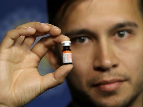 Dr. Nicholas Etches, the medical officer of health for the Calgary area, holds naloxone, a medication that reverses the effects of overdoses on opioids, including fentanyl, during a press conference at CPS headquarters in Calgary on August 13, 2015.