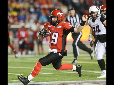 Calgary Stampeders quarterback Bo Levi Mitchell, centre, slides in for a down against the Ottawa Redblacks at McMahon Stadium in Calgary on Saturday, Aug. 15, 2015. The Calgary Stampeders led the Ottawa Redblacks, 31-3, at the half in regular season CFL play.