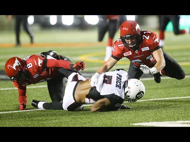 Calgary Stampeders Fred Bennett, left, and Adam Berger take out Ottawa Redblacks wide receiver Maurice Price at McMahon Stadium in Calgary on Saturday, Aug. 15, 2015. The Calgary Stampeders won over the Ottawa Redblacks, 48-3, in regular season CFL play.