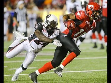 Ottawa Redblacks defensive back Jerrell Gavins, left, leaps to take out Calgary Stampeder slotback Marquay Mcdaniel at McMahon Stadium in Calgary on Saturday, Aug. 15, 2015. The Calgary Stampeders won over the Ottawa Redblacks, 48-3, in regular season CFL play.