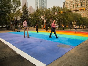 Pedestrians cross the city's very first rainbow crosswalk, painted in preparation for the upcoming 25th annual Calgary Pride Festival, at city hall in Calgary on Tuesday, Aug. 25, 2015.