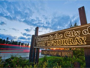 A Welcome to Fort McMurray sign stands on the side of Highway 63 on the south end of Fort McMurray, Alta. on June 19, 2013.