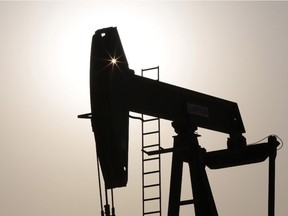 An oil pump works at sunset Thursday in the desert oil fields of Sakhir, Bahrain.
