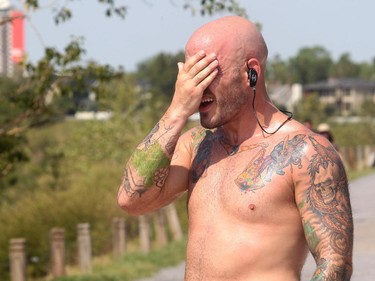 Aaron Gallant wipes away the sweat after multiple funds up and down the McHugh Bluff steps above Memorial Drive in the height of the afternoon heat Monday August 10, 2015. The weather is expected to stay hot all week. Gallant, a middleweight boxer, was training for a bout coming August 21 at Century Casino.