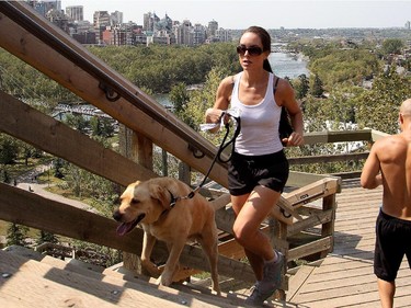 Courtney Lavalee and her golden lab Reese work up a hot sweat as he runs up the McHugh Bluff steps above Memorial Drive Monday August 10, 2015. The weather is expected to stay hot all week.