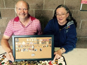 Club vice-president Mark Mogen and club member Jeannette Wilson of the Calgary International Pin Club display some of their lapel pins as they gear up for 25th annual Festival of Pins.