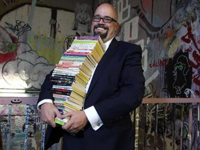 Derek Beaulieu holds a stack of titles at the Alberta College of Art and Design where he will be teaching a course based around Choose Your Own Adventure books.