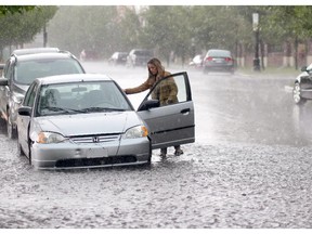 A woman moves her car during the storm in Calgary on August 5, 2015.