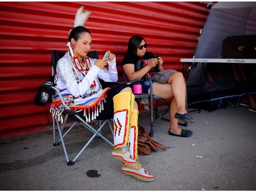 Carly Weasel Child, from Siksika Nation and the 2014 Calgary Stampede Indian Princess, left, takes some downtime before competing in the women's jingle dance at the Siksika Nation Fair Powwow.