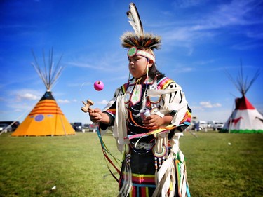 Daryon Delaney, 11, from the Kainai Nation plays kendama before competing in junior boys grass dance at the Siksika Nation Fair Powwow.