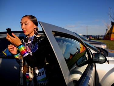 Janine Ironquill, from Nakoda Nation in Saskatchewan, checks her make-up before competing in the old style jingle dance at the Siksika Nation Fair Powwow.