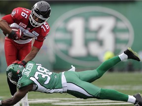 Calgary Stampeders' Marquay McDaniel fends off Saskatchewan Roughriders defensive back Tristan Jackson during first half CFL action in Regina on Saturday, August 22, 2015.