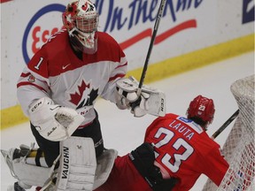 In a heated second period, Team Canada goalie Mason McDonald, a Calgary Flames prospect, knocks Team Russia player Artur Lauta into the net.