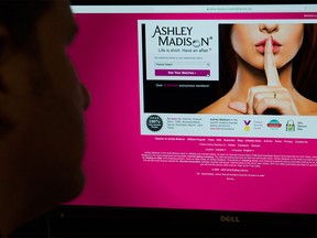 A man looks at the Ashley Madison website in this photo illustration in Toronto on Thursday, August 20, 2015.