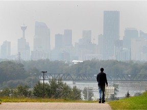 Charlie Coffin walks along the pathway above Max Bell Centre with the smoke-shrouded downtown in the distance. Barry Cooper says environmentalists should take the blame for the forest fires causing all the smoky air.