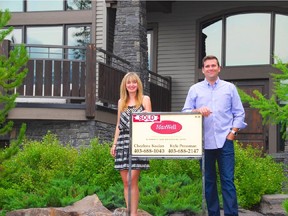 Chezlene Kocian and Kyle Pressman, realtors with MaxWell South Star Realty, outside a luxury home they recently sold in Canmore. Photo by Trevor Martin