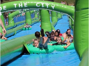 Calgarians embrace their inner child as they enjoy the Slide the City on 10th Street in Calgary on August 1, 2015.